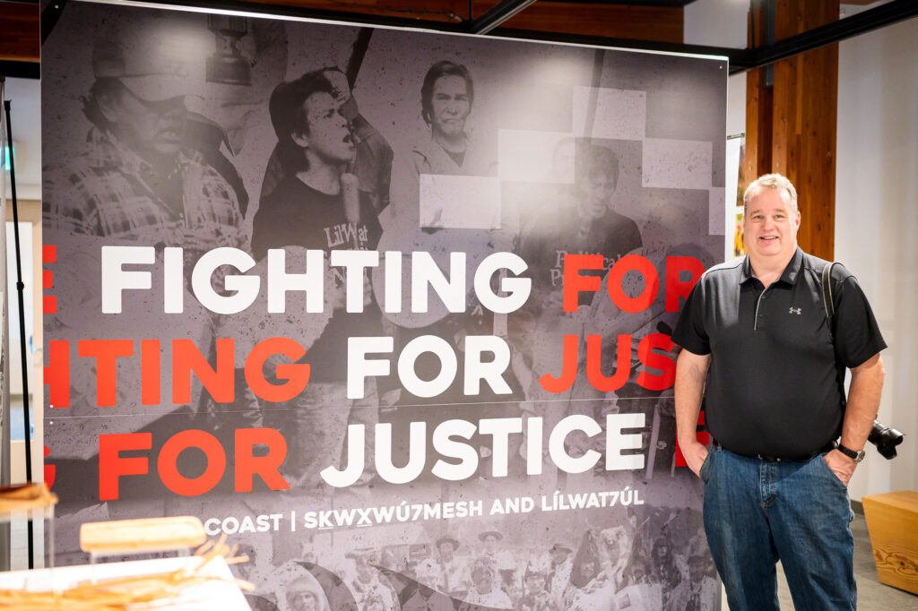 Whistler photographer David Buzzard with at the Fighting for Justice exhibit at the Squamish Lil’Wat Cultural Centre in Whistler BC, Canada. Buzzard photographed the 1990 Mt. Currie road blockade, and the photos are part of the exhibit. February 9th, 2024.